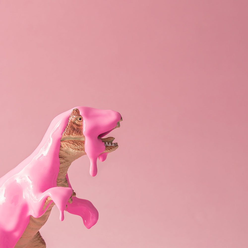 Speelgoed t-rex met roze vloeistof eroverheen